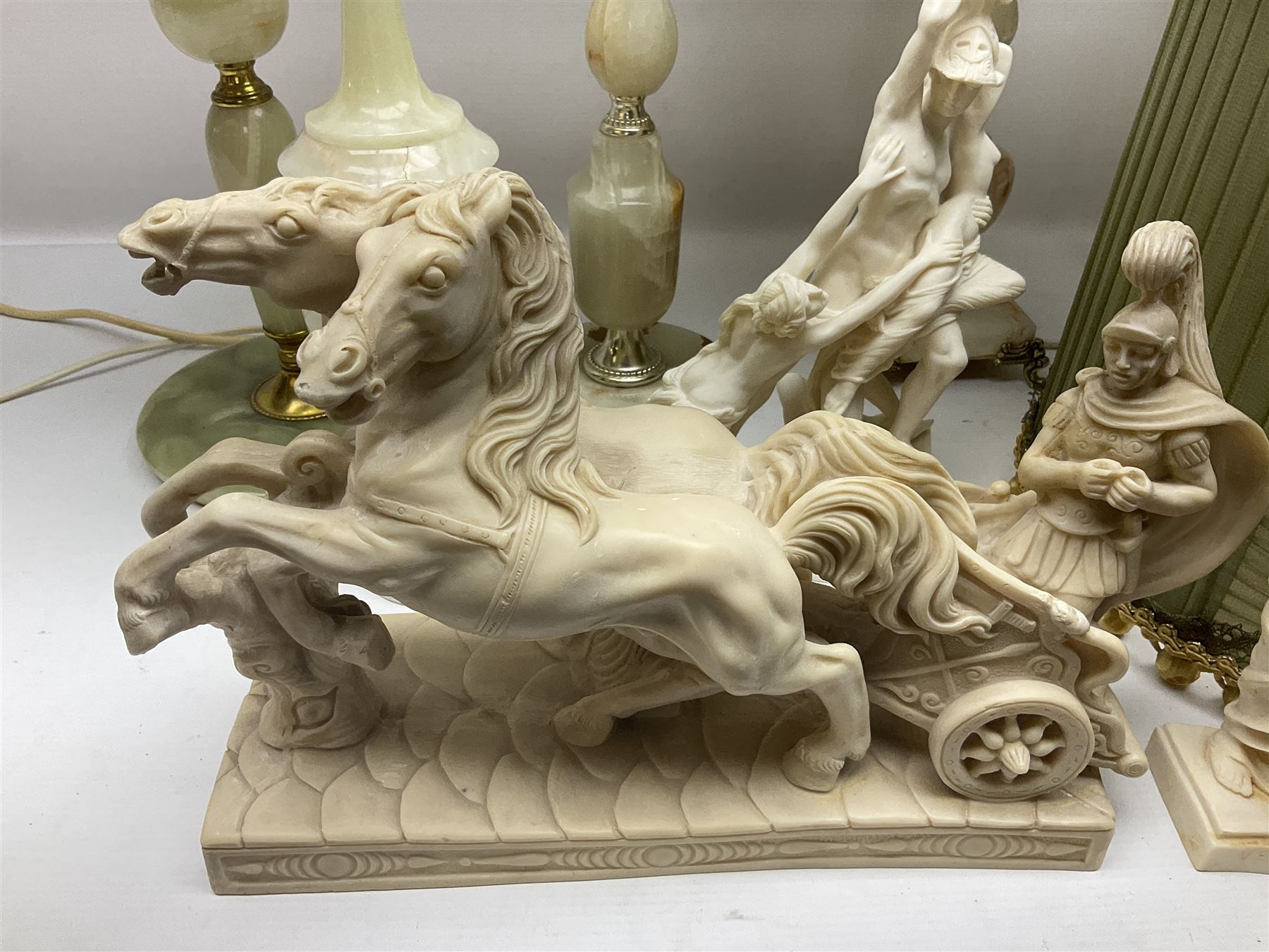 Onyx table lamp, with knopped stem and cream and green tassel shade, together with three smaller similar onyx lamps, classical style alabaster figures and a covered onyx jar