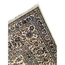 Persian Kashan ivory ground carpet, the field decorated with interlacing leafy branches and stylised plant motifs, repeating border with multiple guards