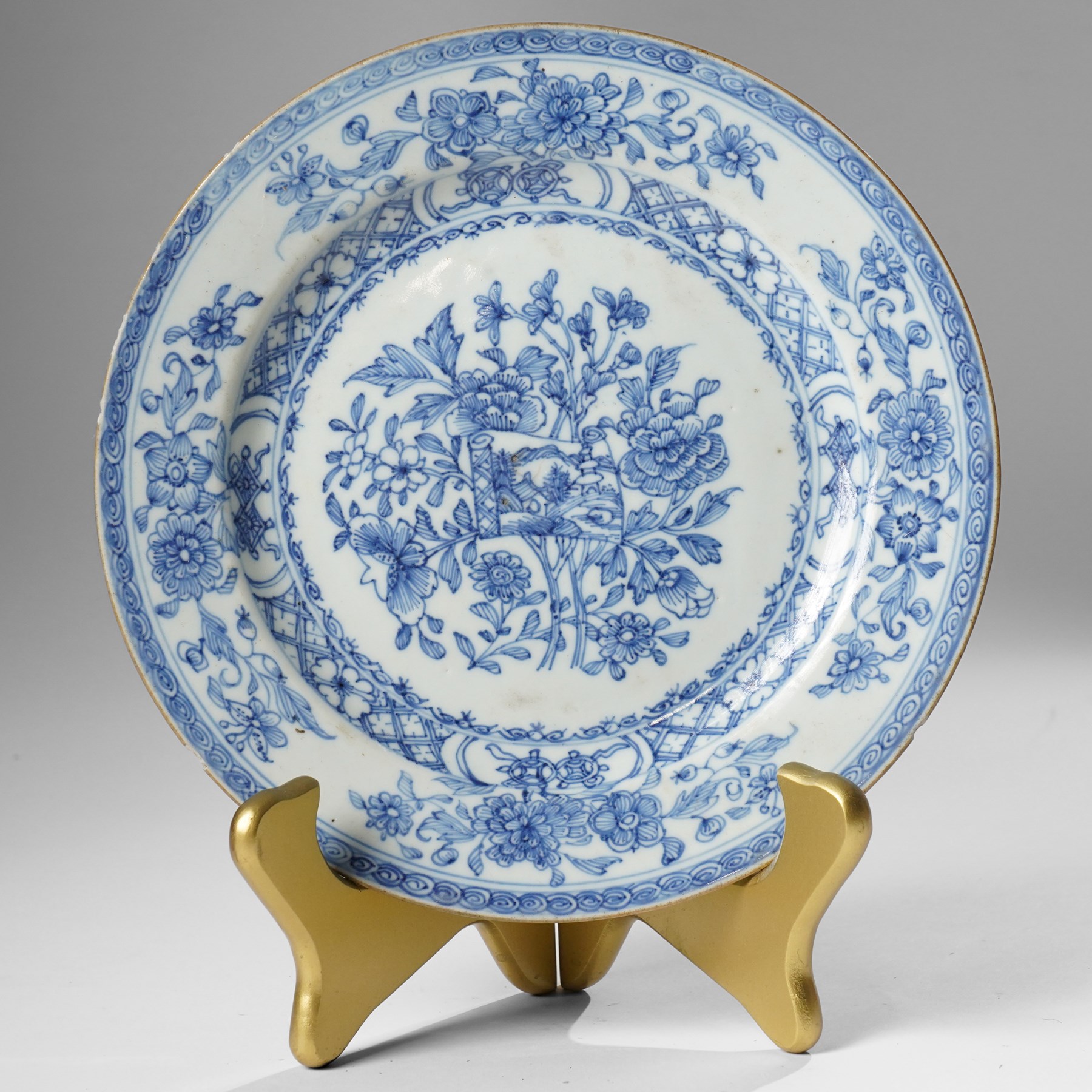 Pair of Chinese Kangxi period blue and white plates, painted in underglaze blue, decorated centrally with an unrolled handscroll revealing a shanshui landscape among foliage, D23cm (2)