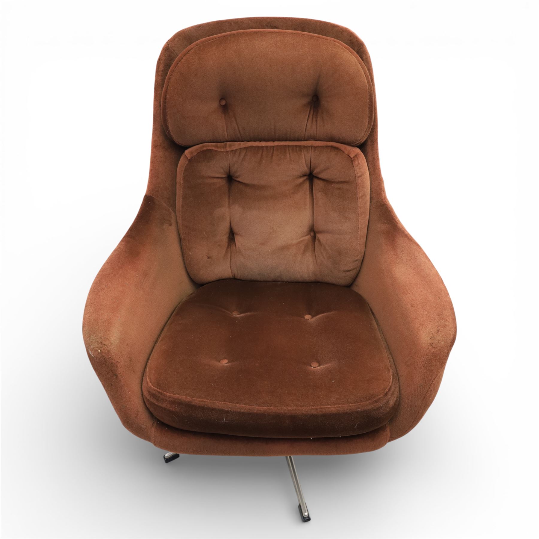 Pair of mid 20th century brown velvet swivel lounge chairs and matching footstool, the shaped and padded back with buttoned segmented cushion over conforming seat cushion, flared armrests and moulded sides, raised on a five point metal swivel base, the footstool en suite with buttoned cushion and matching metal base