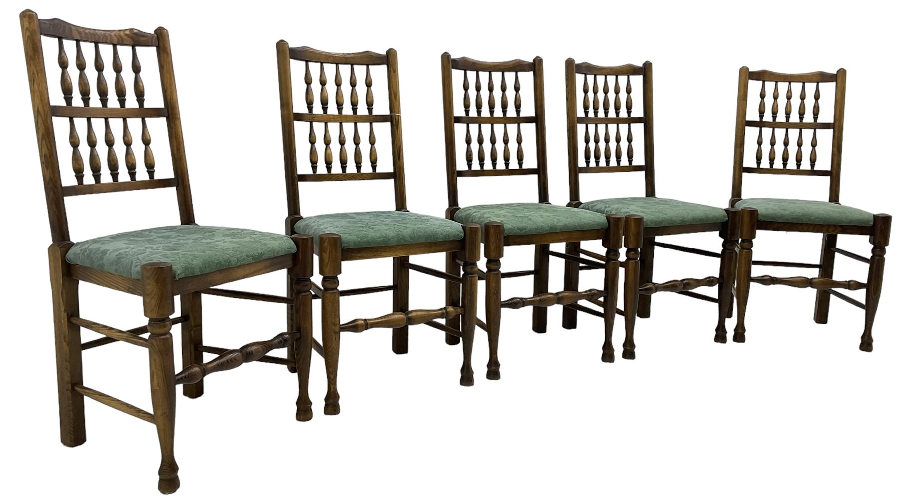 Set of five Lancashire design elm spindle back chairs, shaped cresting rail over two rows of five spindles, upholstered drop-on seats, on turned front supports united by turned stretchers  