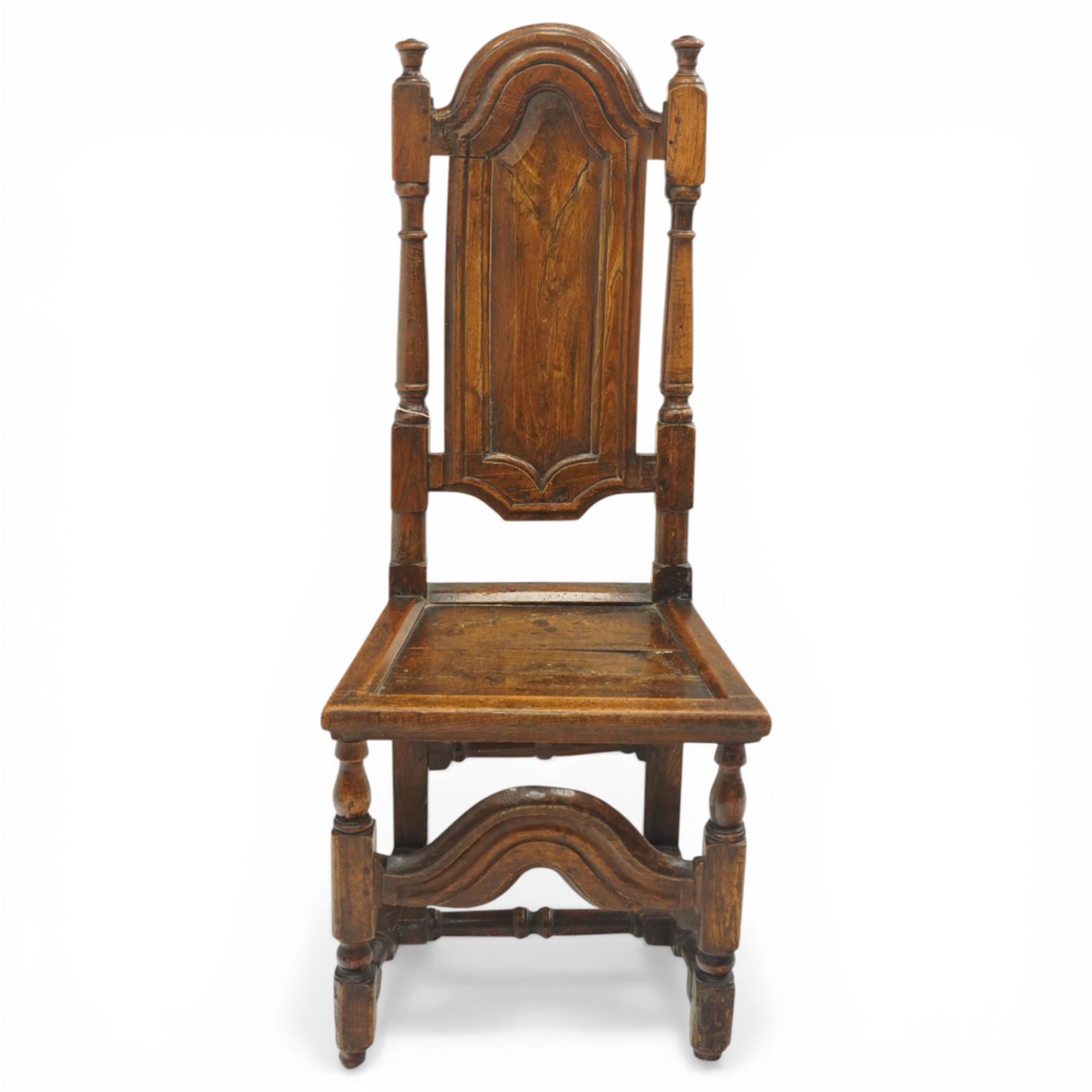 17th century oak and elm hall chair, the high-back with shield-shaped fielded panelling flanked by turned uprights, over a panelled seat, raised on turned supports united by H-stretcher with moulded serpentine front-stretcher