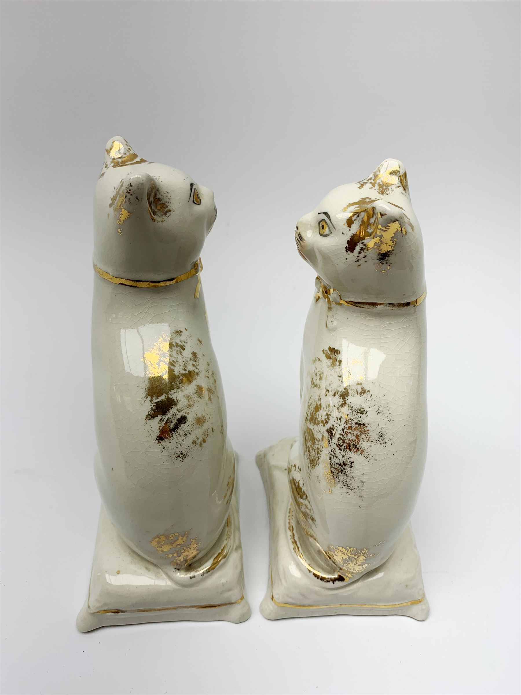 Pair of Victorian Staffordshire cats, modelled seated upon cushions, with gilt detail throughout, H18cm