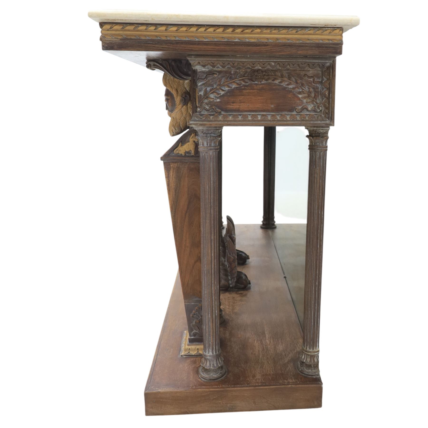 20th century carved hardwood console table in Renaissance taste, moulded marble slab top over a frieze decorated with festoons and roundels, the angles carved with grotesque mask brackets, supported by six fluted columns with carved mask and paw feet terminals, on a stepped plinth base with mirrored back