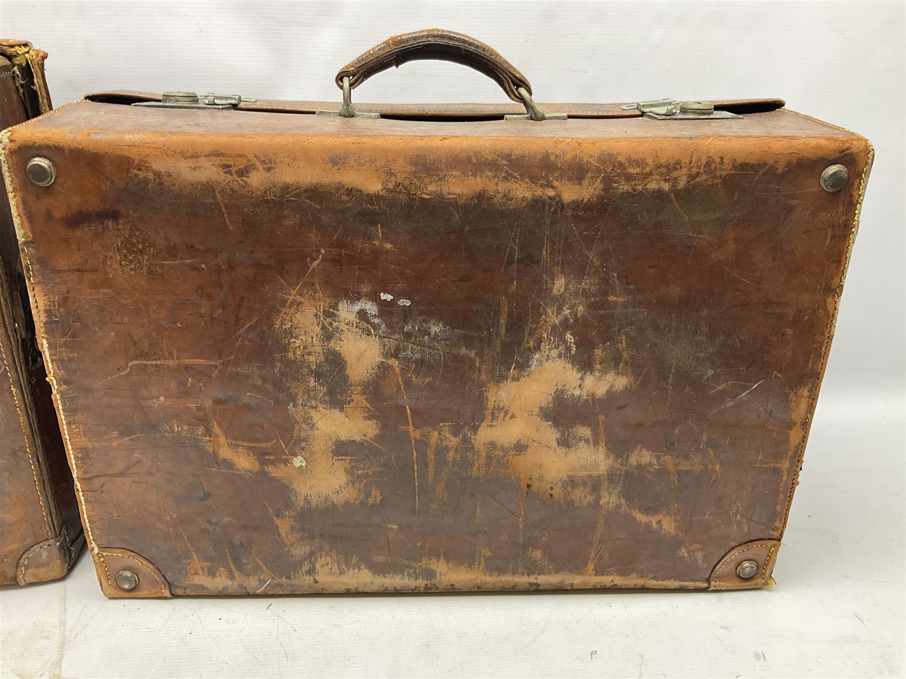 Early 20th century leather suitcase marked to the top 'Major P.M. Newton R.E. Crossways, Bridlington, East Yorkshire' 60 x 40cm; another similar leather suitcase marked W.D. to the lid; three post-WW2 respirators; and three unopened pairs of British Army N.B.C. (Nuclear Biological Chemical) No.1 Mk.III Trousers Protective (8)
