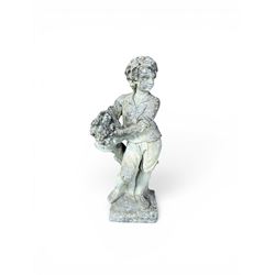 Weathered cast stone garden figure depicting a child holding a fruit basket