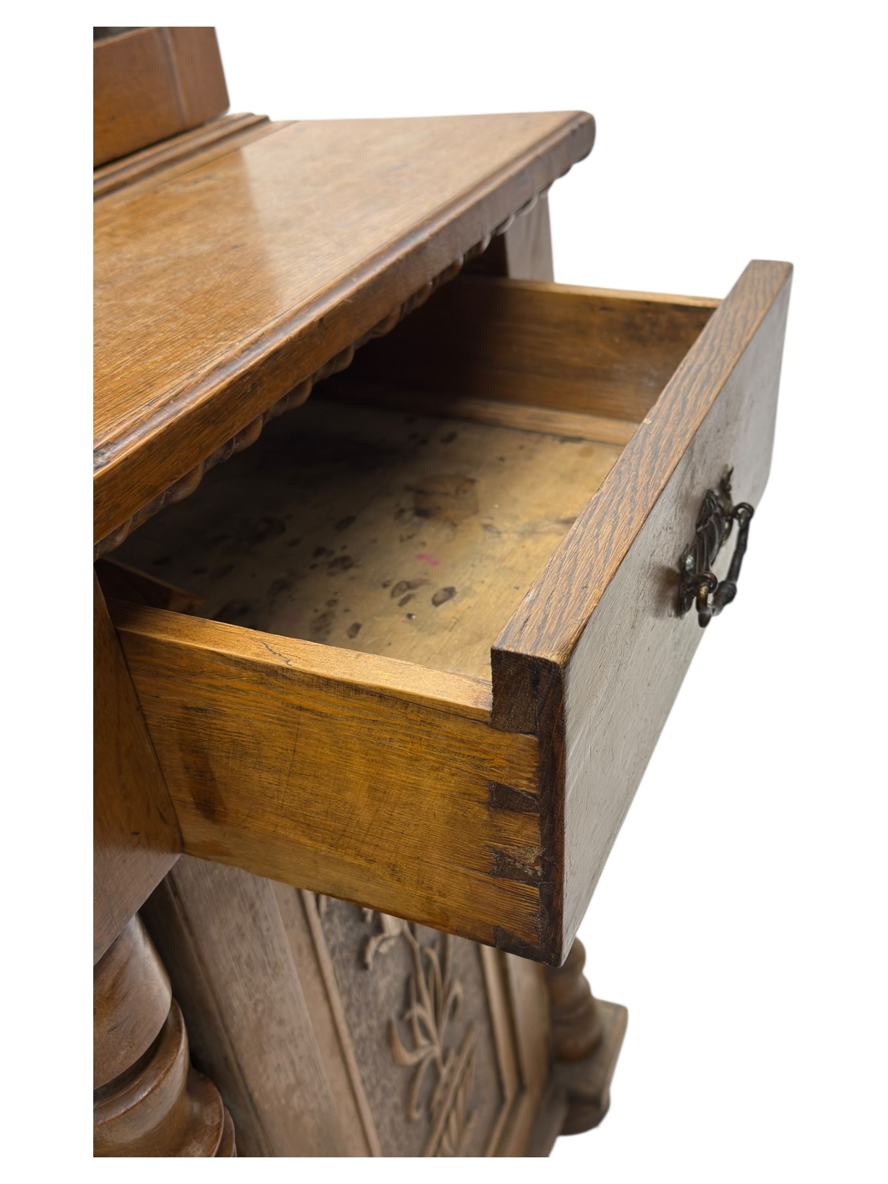 Late 19th century pine dresser, the projecting cornice with dentil and spindle moulded frieze above a three-tier plate shelves, flanked by glazed doors, the base fitted with three frieze drawers over arched apron and carved floral panelled cupboard doors, raised on turned feet