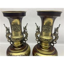Pair of oriental twin handled brass vases decorated with stylised dragons, together with a brass tureen with central chimney, the ring shaped lift off lid decorated with band of dragons and key fret border, tallest H35cm