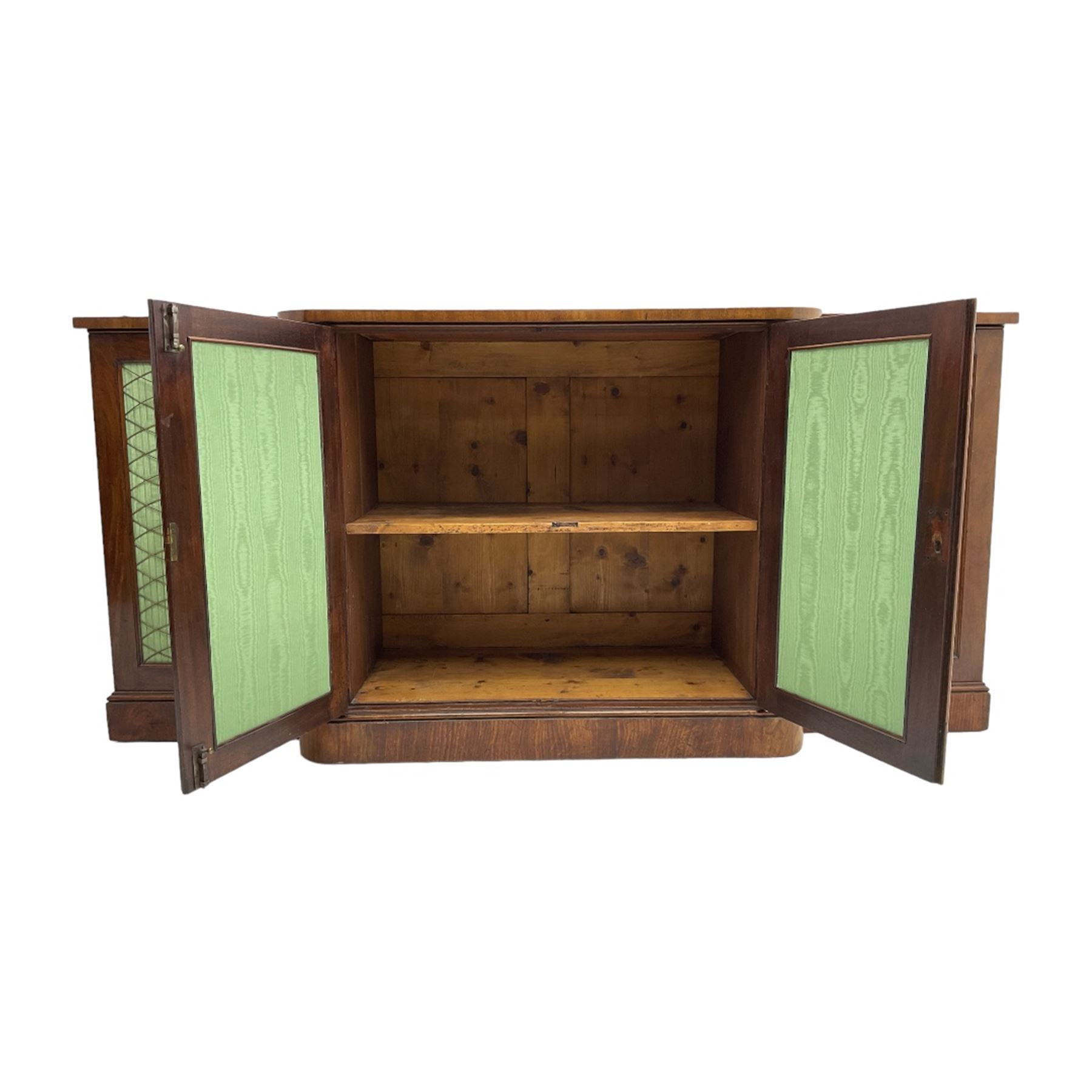 19th century mahogany break-front sideboard, raised brass gallery back with Greek key design, fitted with four cupboard doors, their pleated green fabric overlain with gilt metal grilles, lower moulded edge over plinth base
