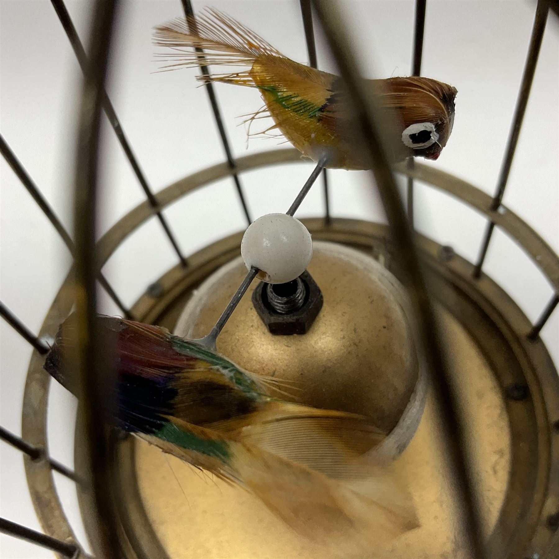 Automation bird cage clock of predominantly brass construction with central rotating orb and two birds with feathered decoration, H19cm