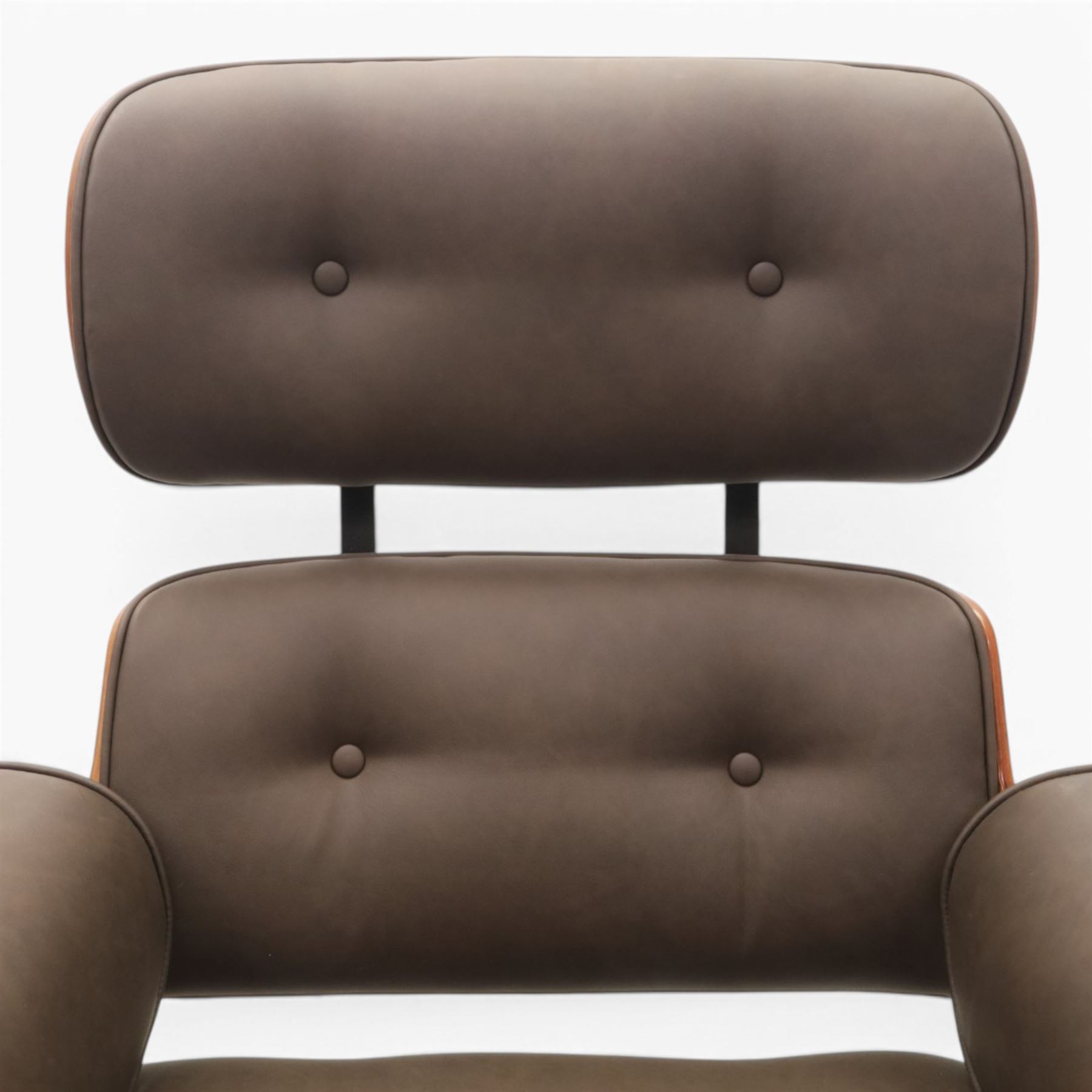 In the manner of Eames' Lounge chair, contemporary brown leather and plywood recliner and footstool, padded leather seat and arm rests, plywood backs raised on a black metal frames, reclines and swivels on a five point base  