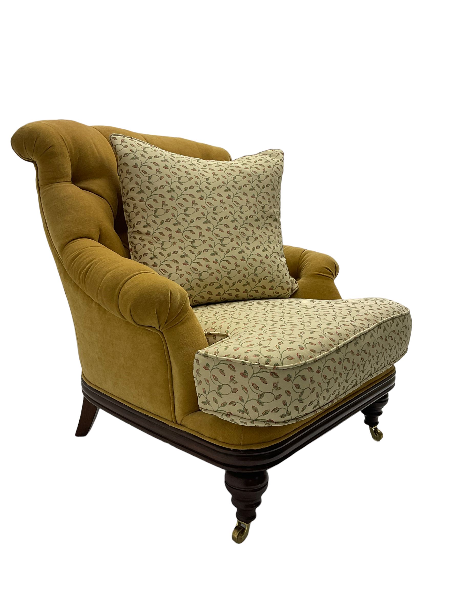Victorian style armchair, upholstered in buttoned fabric with contrasting foliate pattern seat and scatter cushion, on turned front feet with castors