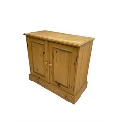 Traditional pine low cupboard, fitted with two panelled doors, on plinth base