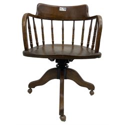 Early 20th century oak framed swivel Captain's chair, tub shaped back with turned spindle supports over saddle shaped seat, quadriform base on castors