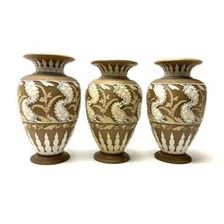 A set of three 19th century Doulton Lambeth silicon ware vases, each of a baluster form with white foliate decoration, with impressed and incised marks beneath, including makers marks, H24cm. 