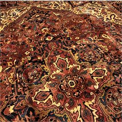 Persian Heriz golden red ground carpet, large floral medallion on field decorated with interlaced foliate, the border decorated with plant motifs 