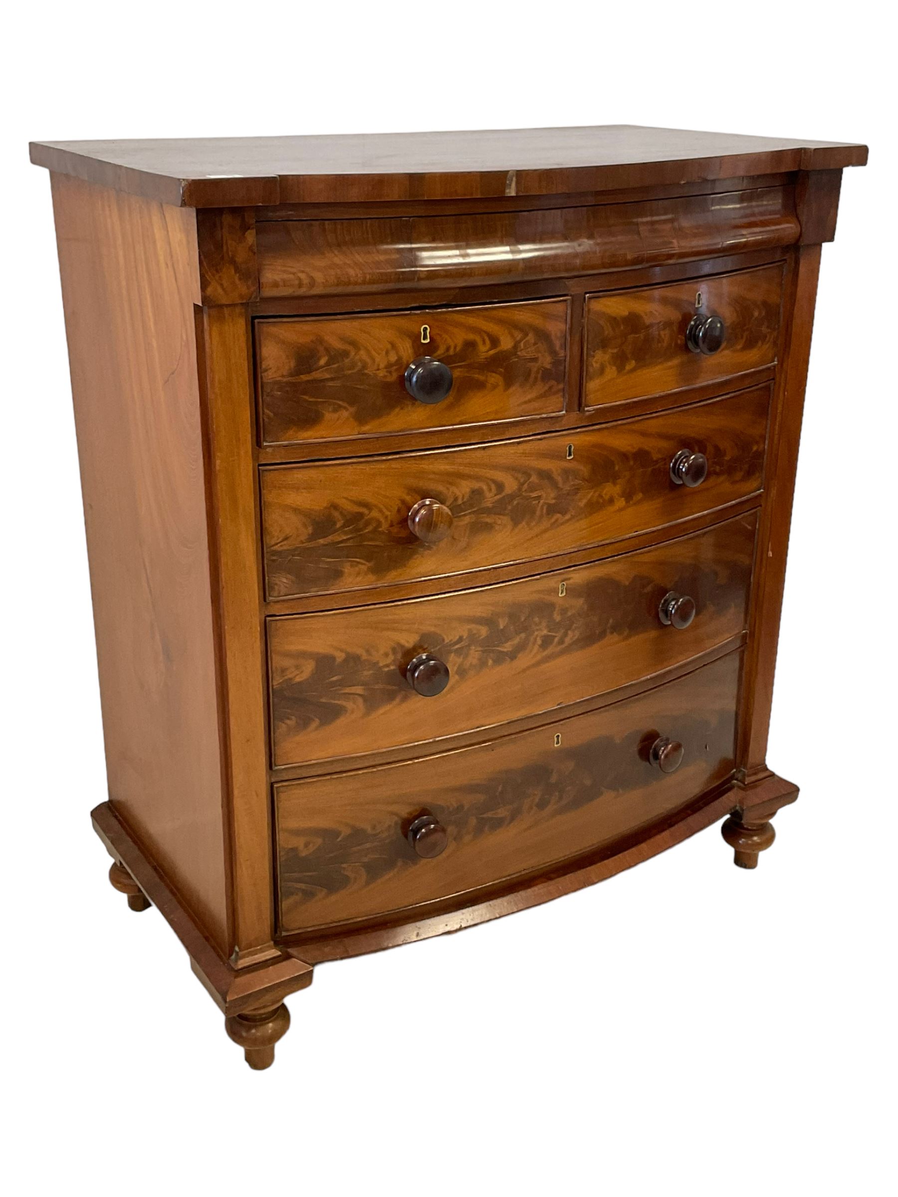Late 19th century mahogany bow-front chest, fitted with banded cushion drawer with secret catch, above two short over three long graduating drawers, each cock-beaded with turned handles, lower moulded edge over turned feet