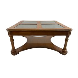 Coffee table, square top with cane work insets, raised on four fluted column supports joined by shaped base