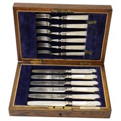 Set of six dessert knives and forks with silver collars and mother of pearl handles, silver plated photograph frame and travelling toilet set in leather case