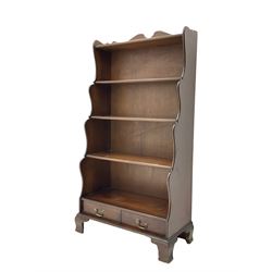 Late 20th century mahogany waterfall bookcase, fitted with two drawers, on bracket feet