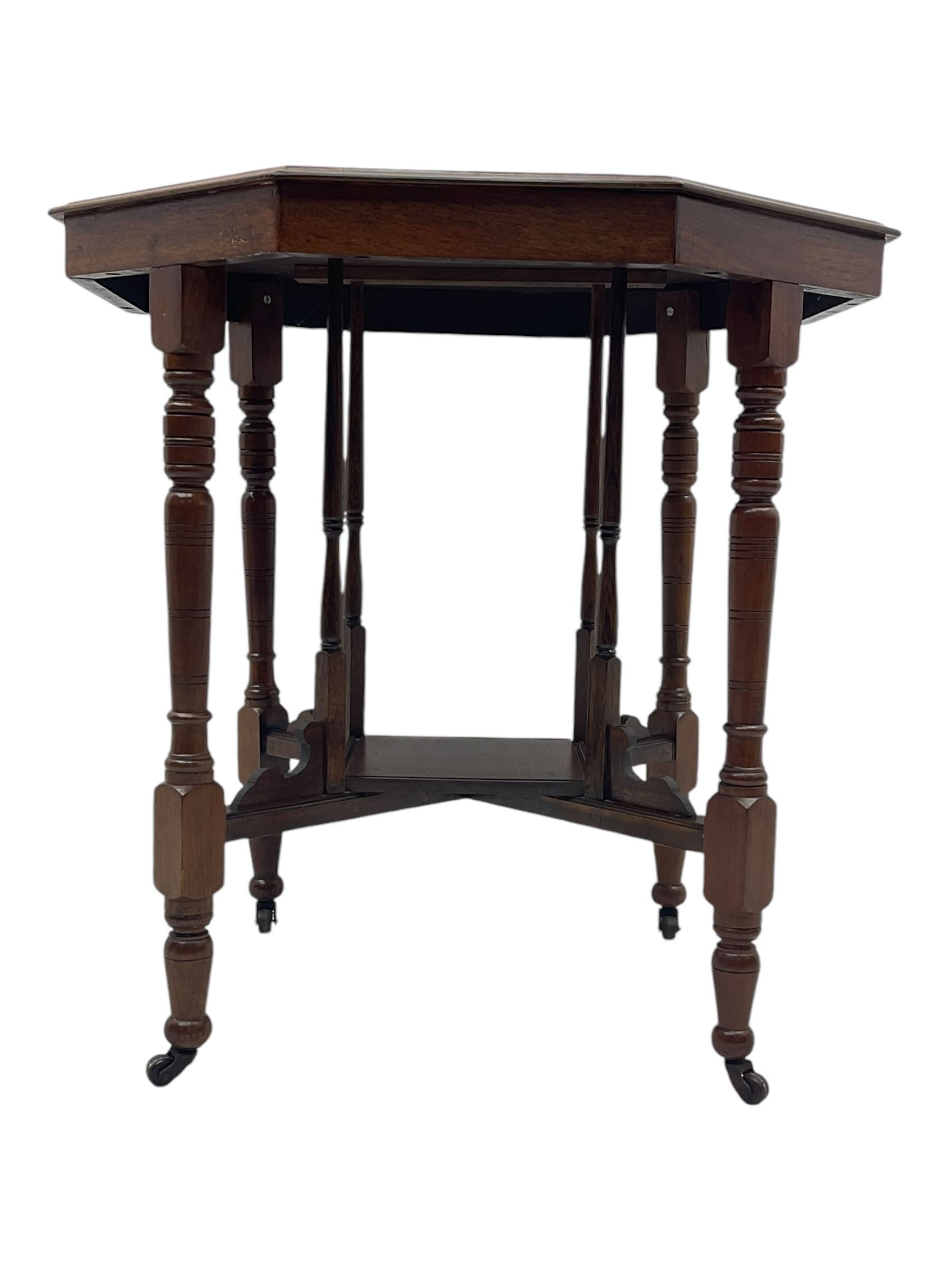 Victorian oak occasional table, octagonal top with bevelled edges, lower section fitted with a square undertier united by decorative shaped stretchers, on turned supports with castors