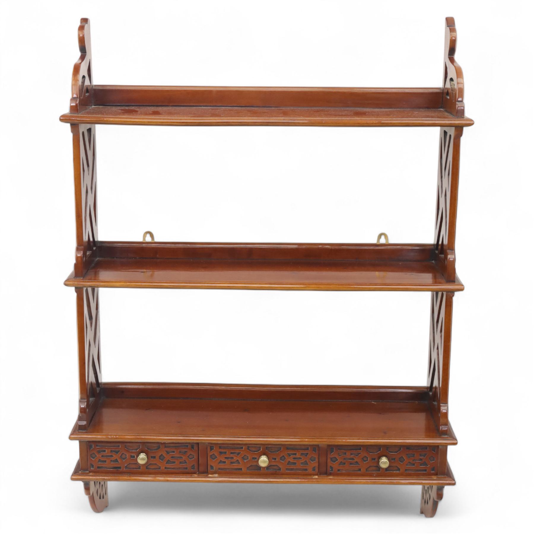 Two mahogany wall hanging items, comprising a French mahogany overmantel mirror with reeded uprights and moulded cornice (H 68cm, W 97cm, D 10cm), together with a mahogany wall shelf unit with three tiers and fretwork sides, the lower section fitted with three small drawers (H 95cm, W 63cm, D 18cm) (2)