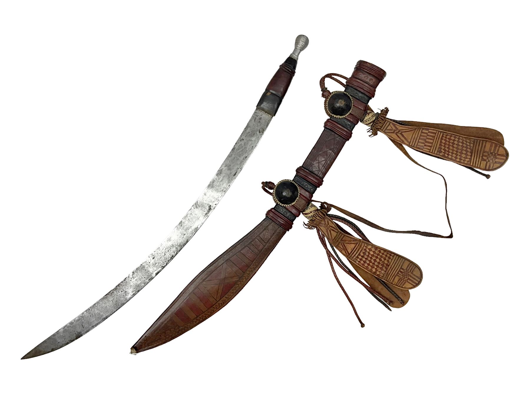 Mandingo sword with 63cm plain curving steel blade and leather covered grip with white metal ribbed spherical pommel; in decorative leather leaf scabbard with plaited tassels and shoulder strap L78cm overall