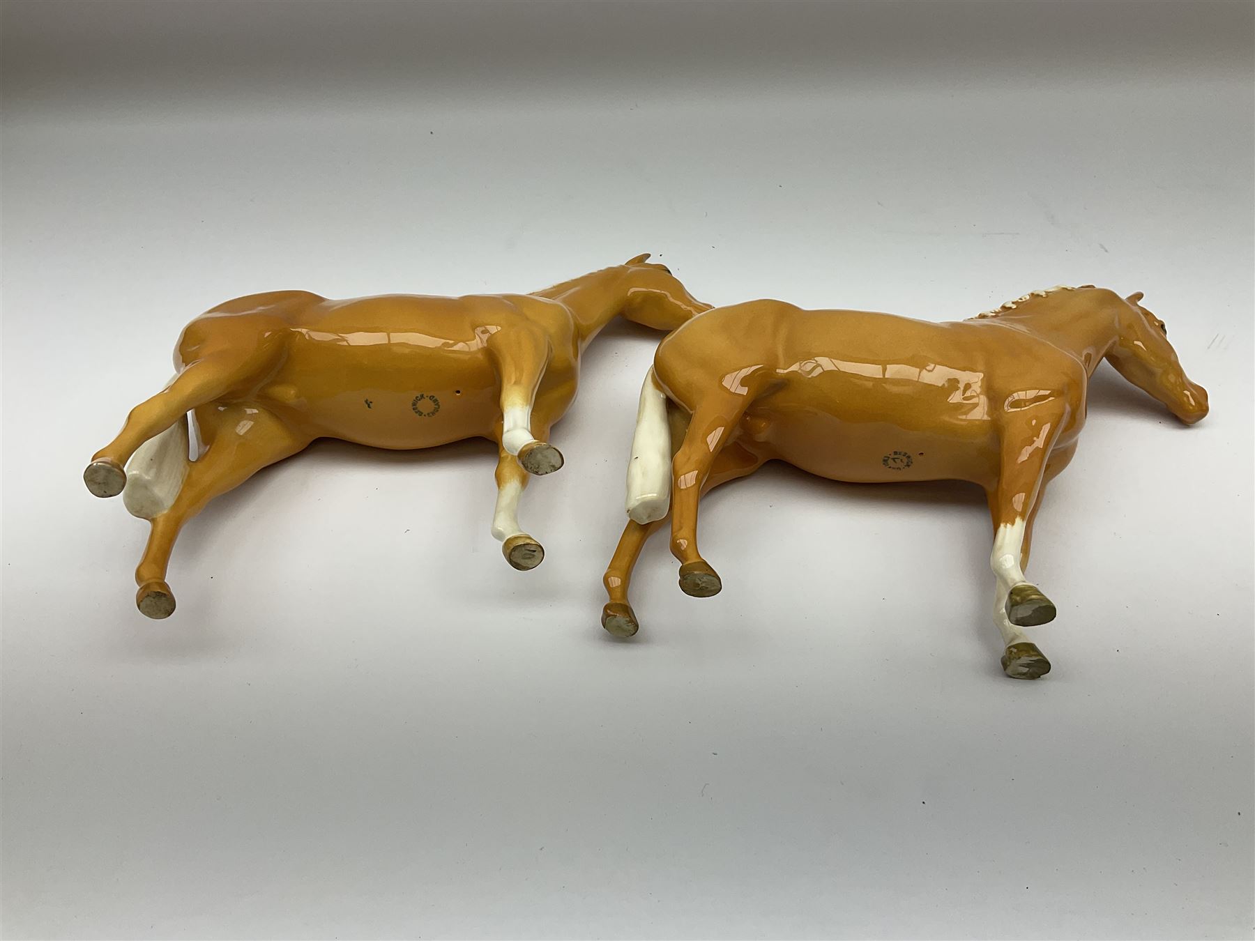 Two Beswick Palomino horse figures, comprising 'Imperial' Palomino, model no. 1557, designed by Albert Hallam and James Hayward, together with Palomino Arab model no. 1771, both stamped, tallest H20cm