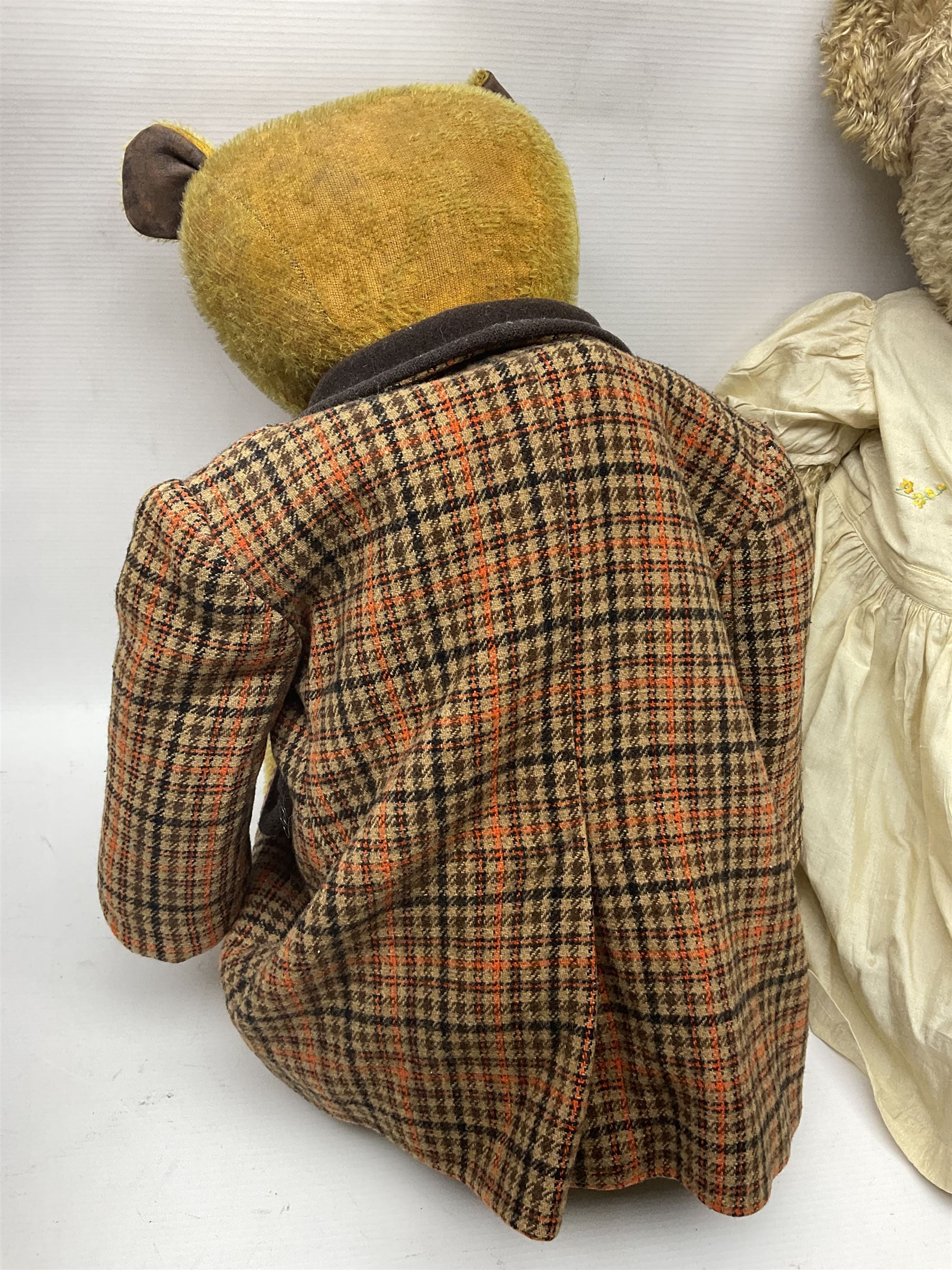 Two early 20th century straw filled jointed teddy bears, first example wearing a tweed jacket bearing Geoffrey Saville label, with leather padded paws and ears, horizontally stitched nose and humpback; second example with applied eyes, vertically stitched nose and faux leather paw pads, both with growler mechanisms, tallest H74cm 