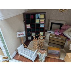 Two modern three storey dolls houses, each painted green with decorated interiors, both upon a single white wooden base, together with a large collection of dolls house furniture, accessories and figures 