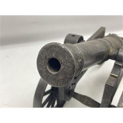 Victorian cast-iron and steel signal cannon, approximately half-inch bore, with 23cm ringed barrel and cylindrical trunnions, on a cast iron carriage with two twelve-spoked wheels and guilloche pierced swept back support, L43cm overall