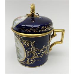 Berlin cabinet chocolate cup and saucer, circa 1900, the cup with angular gilt handle, the domed cover with ribbon modelled ring handle, each hand painted with oval panels of courting couples against a dark blue ground heightened with gilt, each with blue sceptre mark beneath, cup including cover H10.5cm, saucer D13.5cm,