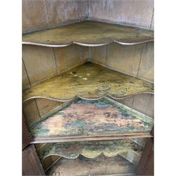 Large George III oak corner cupboard, projecting cornice over two stepped arch doors with fielded panels and blind fret work spandrels, flanked by fluted uprights, cupboard below enclosed by two fielded panel doors, the painted interior fitted with shaped shelves
 