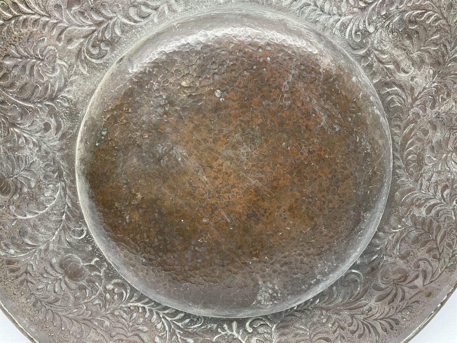 Arts and Crafts Keswick School of Industrial Arts copper charger, decorated with planished centre and repousse scrolling foliate tendrils to rim, D44cm