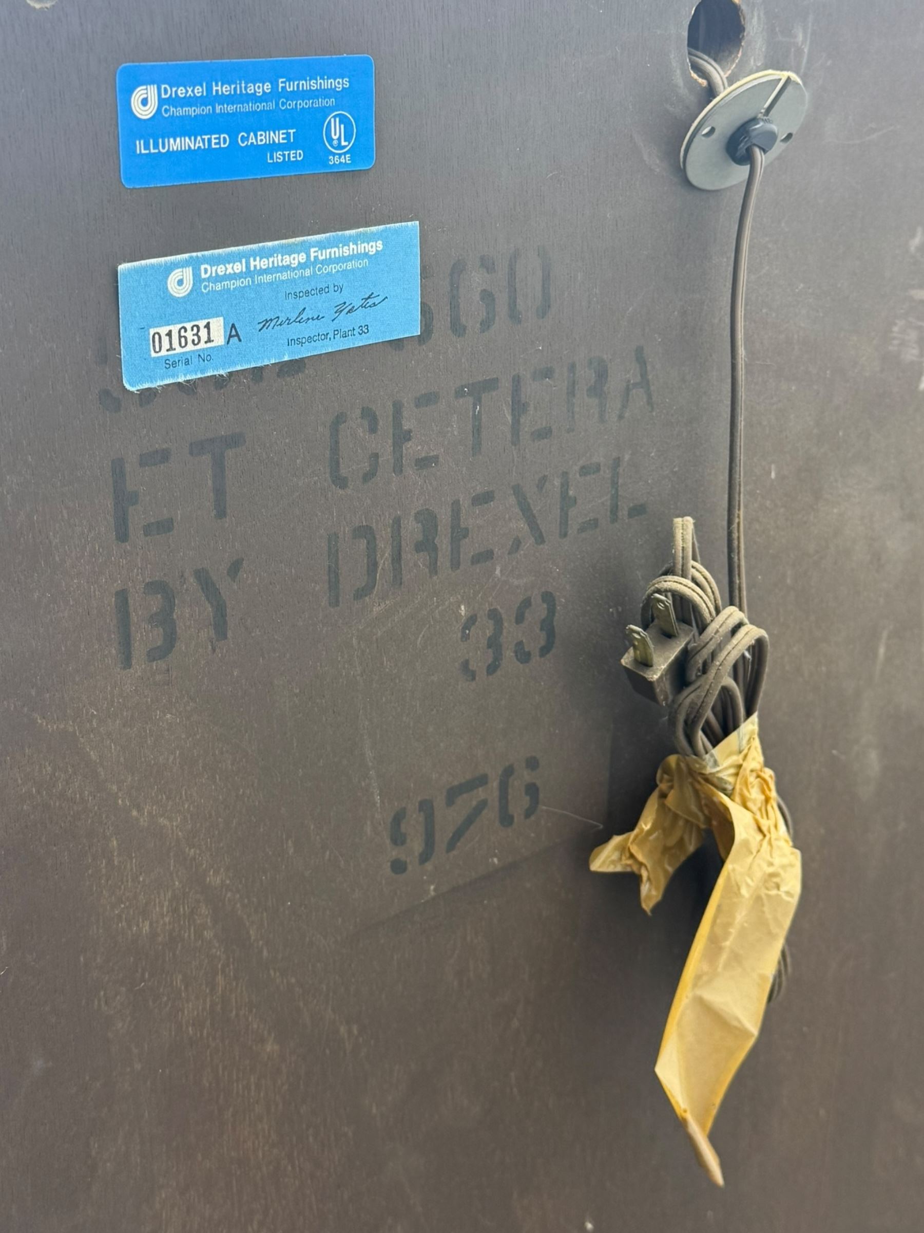 Chinese brown lacquered cocktail cabinet, decorated with gilt scenes of a traditional landscape with figures, pagodas, and mountainous scenery, double doors opening to reveal fitted interior with mirrored back, wine rack, shelves and cupboard, raised on square supports