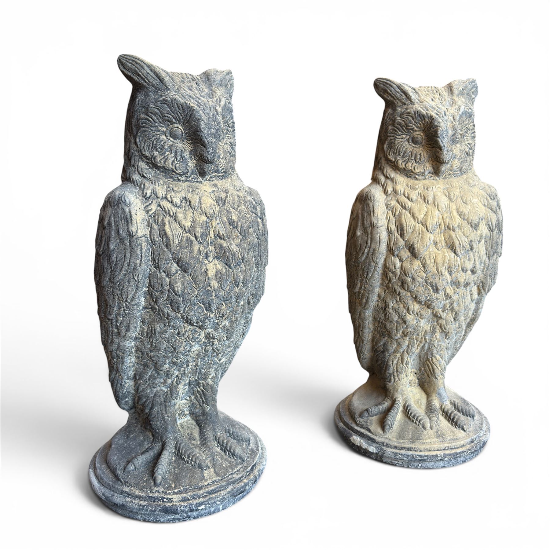 Pair of large composite stone garden statues modelled as standing horned owls, raised on circular bases