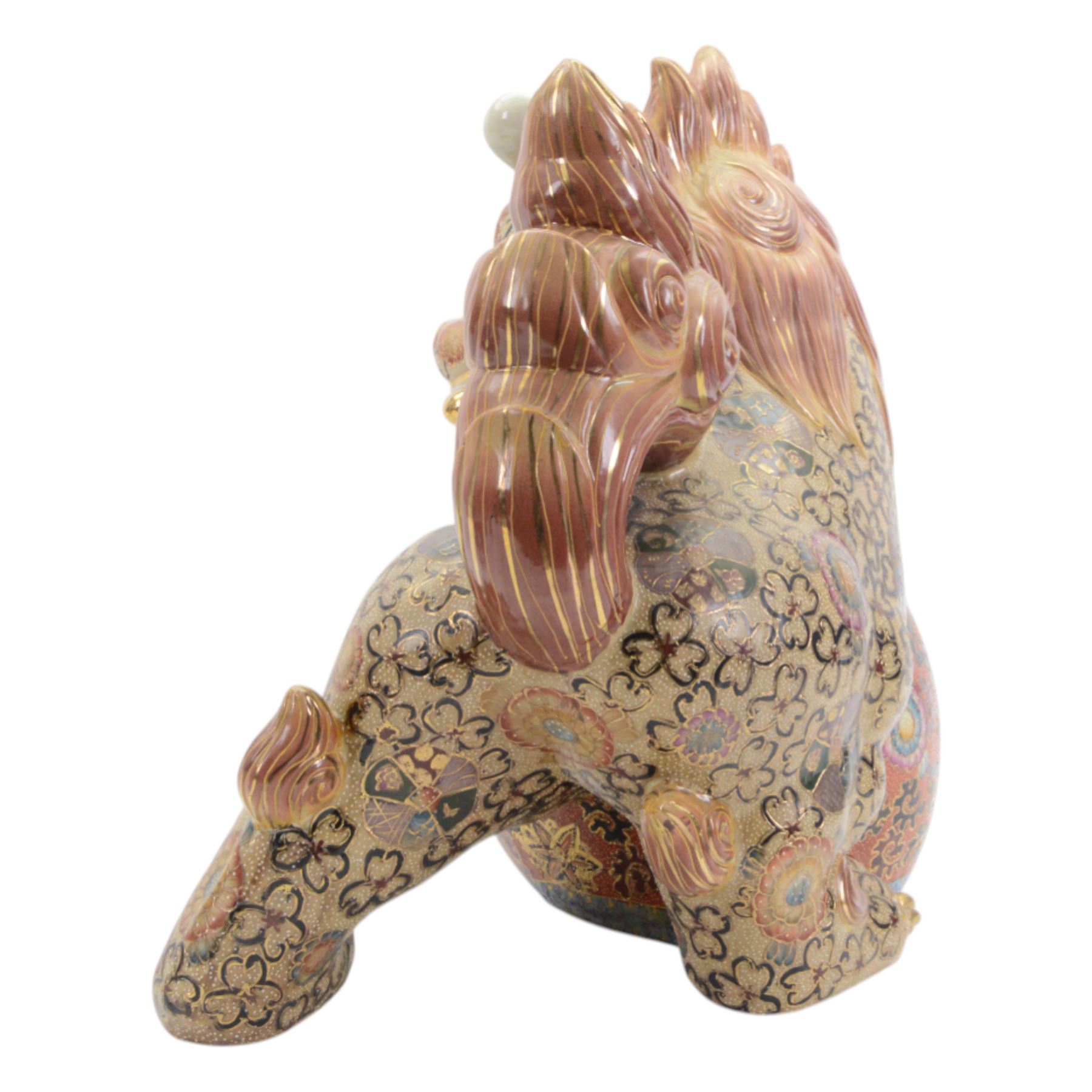 Temple Lion or Dog of Foo, modelled in seated post, one with one front paw resting upon a ball, with sword in mouth, H58cm