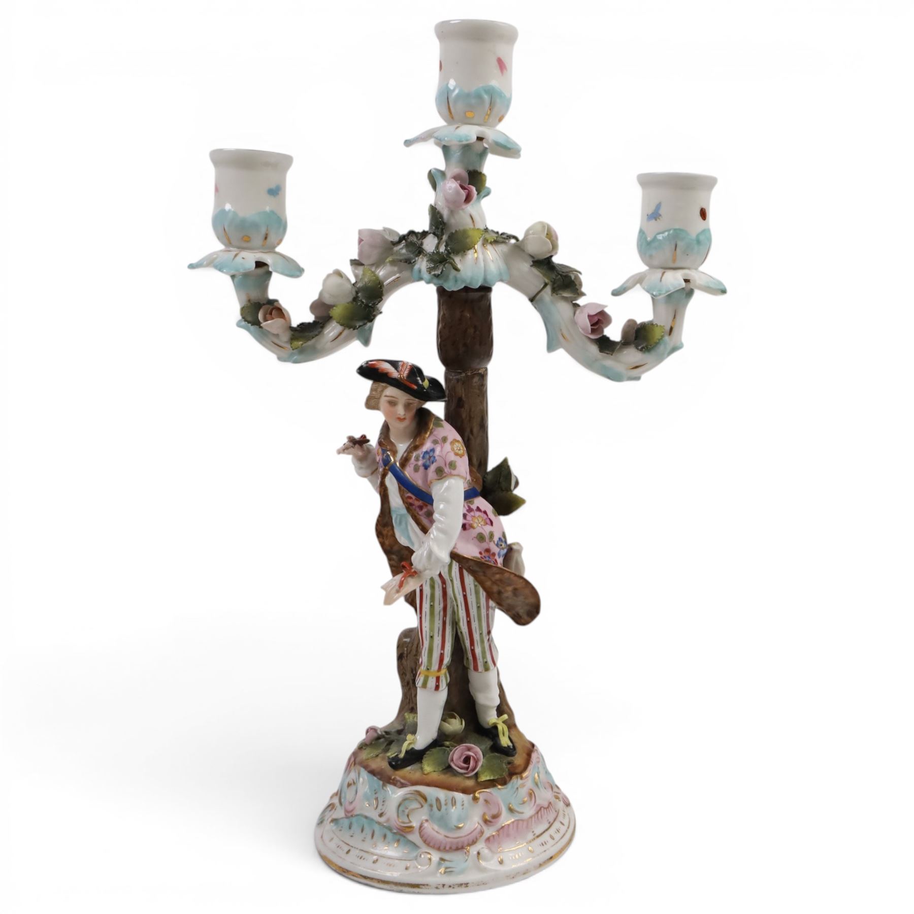 Pair of 19th Century German three-branch figural candlesticks, the figures each in floral dress against a tree, the branches decorated in relief with roses and the sconces painted with insects, H33cm 