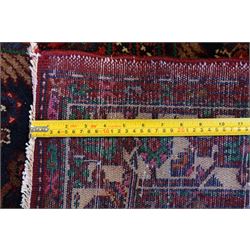North West Persian Malayer hand-knotted runner, indigo field with vertical lozenge medallions surrounded by angular floral sprays, rosettes, and stylized palmettes, field enclosed by serrated ivory spandrels incorporating polychrome floral decoration, framed by ivory ground main border of stylized flowers and hooked devices, flanked by reciprocal guard stripes, cotton fringe ends 