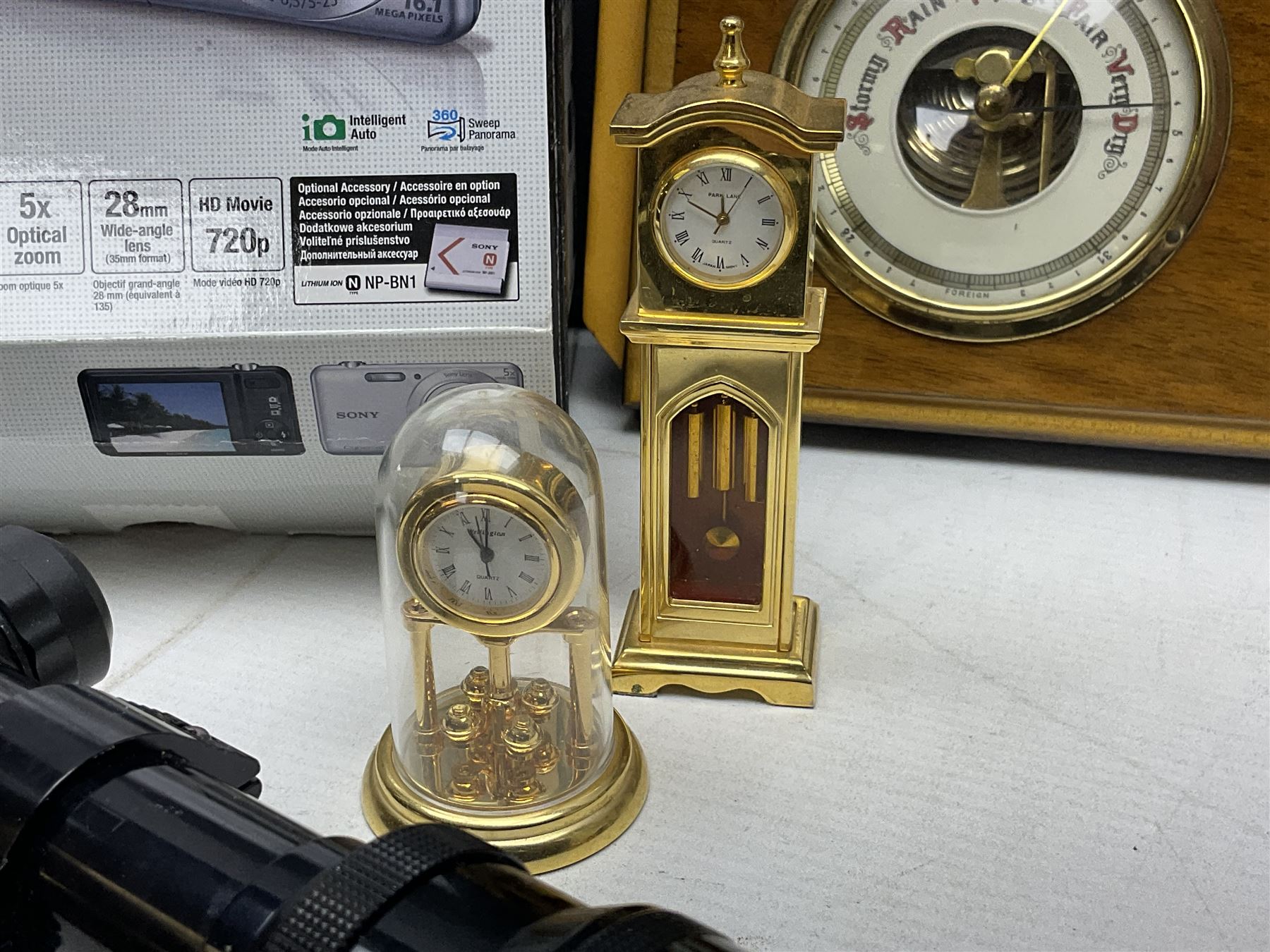 Kundo quartz clock, miniature brass clocks, two barometers, Sony digital camera, Nokia phone, Monarch Remington typewriter, commemorative Shilling etc