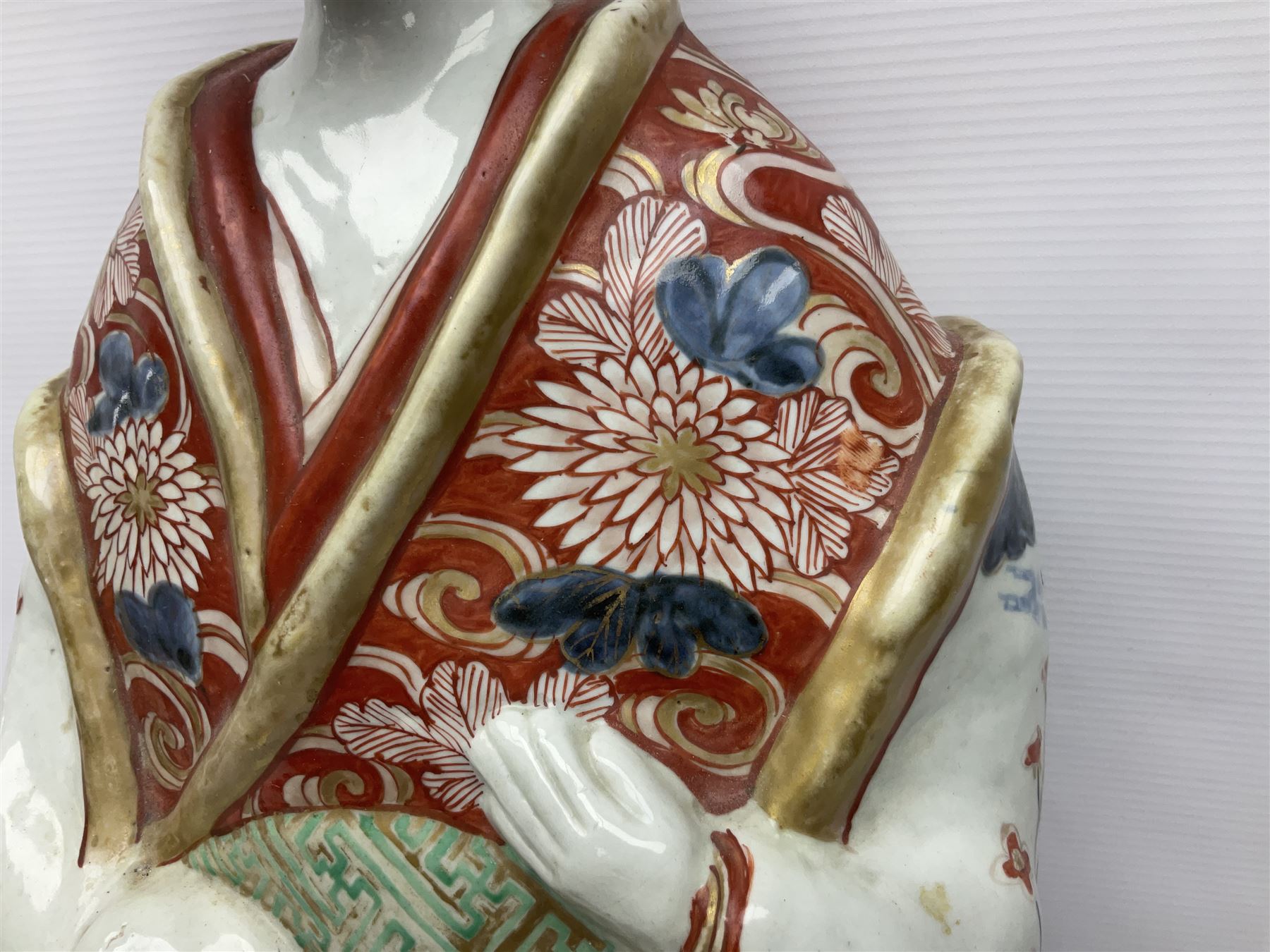 Large Japanese Imari porcelain figure, modelled as a Bijin, wearing a long kimono decorated with apple blossom and leafy branches on a white ground, with gilt detailing, possibly Edo period, H63cm