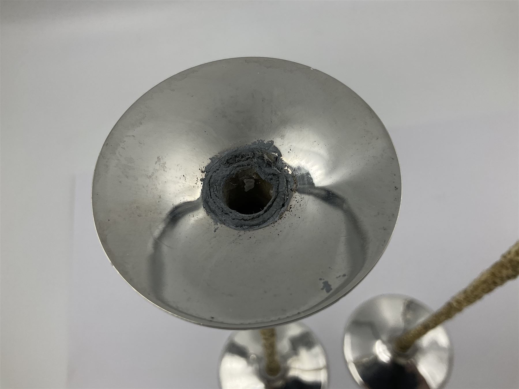 Pair of modern silver candlesticks by Stuart Devlin, the tapering parcel gilt stems with signature textured detailing, each supporting a fluted candle holder and upon a spreading circular foot, hallmarked Stuart Devlin, London 1973, H25cm