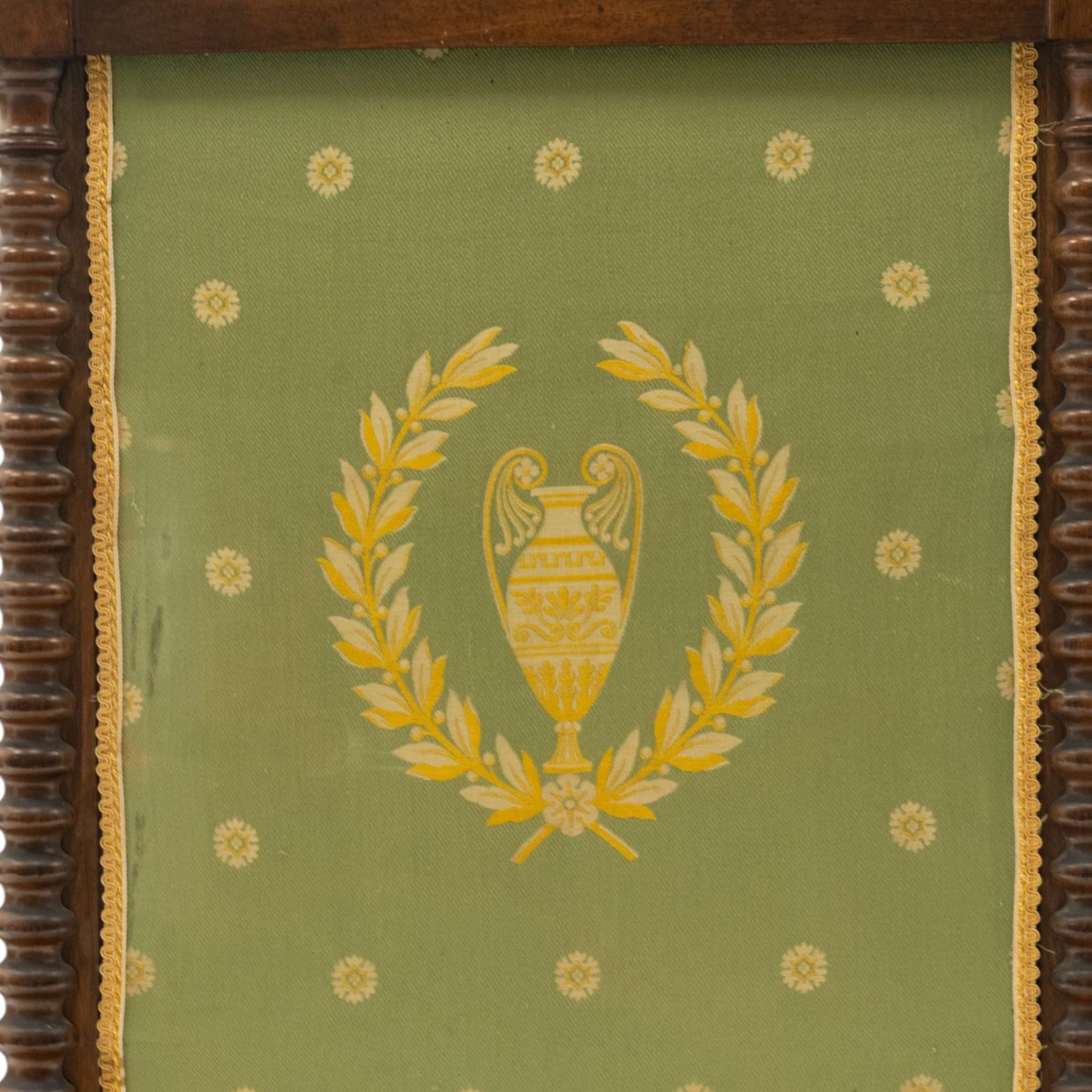 Victorian mahogany firescreen, the rectangular upholstered panel decorated with a Greek urn within laurel wreath on green ground, within spiral turned uprights, on downswept supports united by a turned stretcher