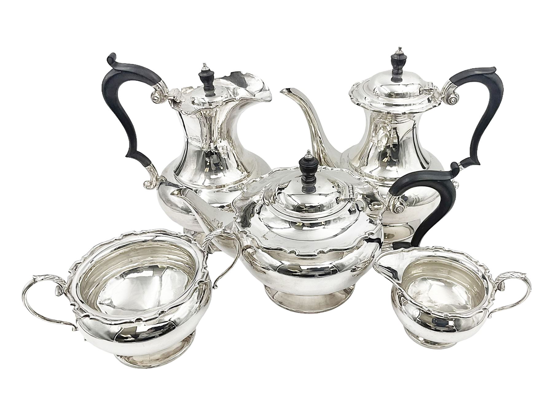 1920s five-piece silver tea service, comprising teapot, coffee pot, hot water pot, twin handled open sucrier and milk jug, each of squat circular form with shaped rim, the teapot, coffee pot and hot water pot each with ebonised handle and finial, the sucrier and milk jug with acanthus capped scroll handles, all upon circular foot, hallmarked R F Mosley & Co, Sheffield 1926 & 1927, tallest H24cm