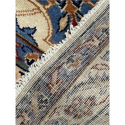 Persian Kashan ivory ground carpet, floral design central medallion surrounded by trailing and interlaced leafy branches with palmettes and flower heads, matching patterned border with guard stripes 