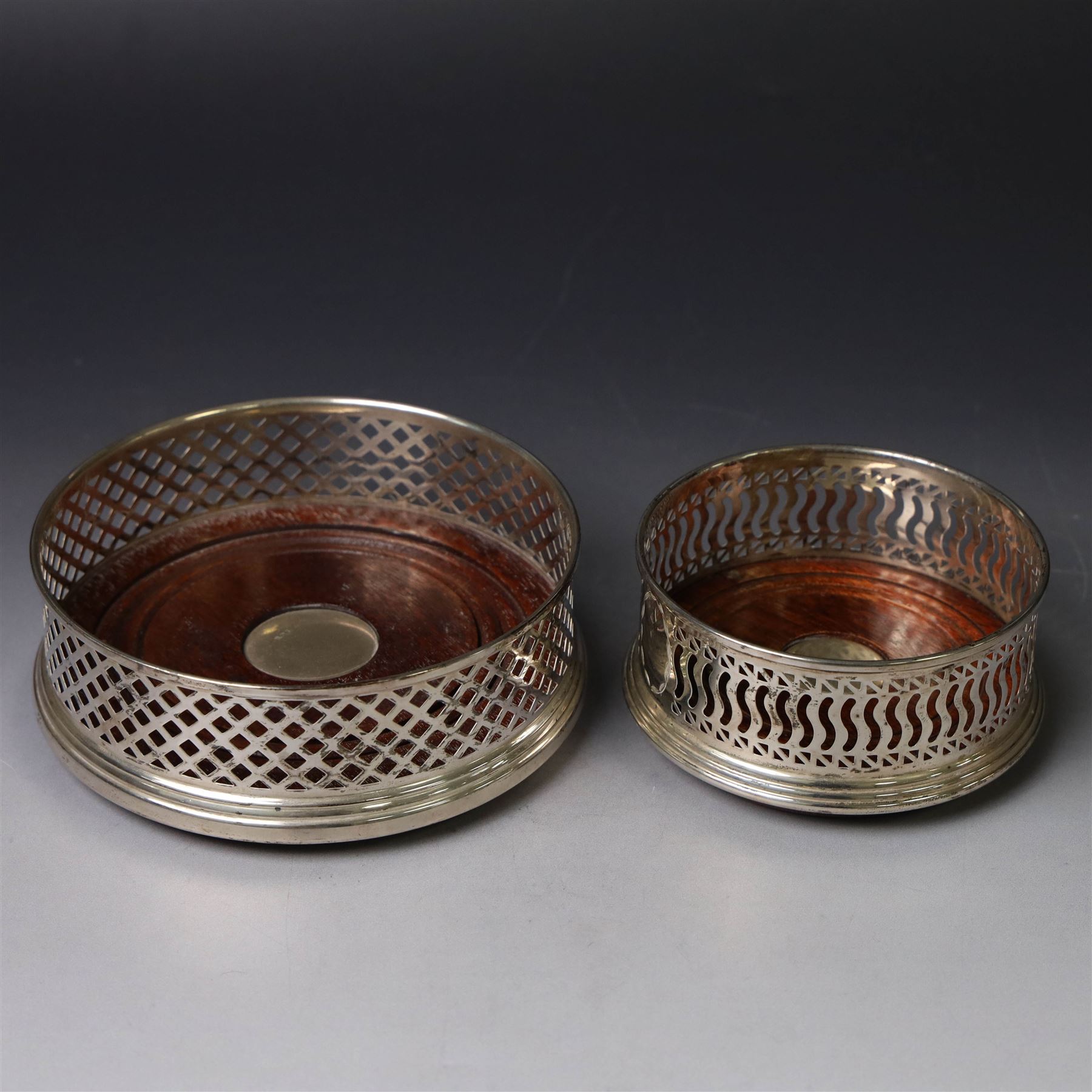 Two silver mounted bottle coasters, the larger example with latticework sides, hallmarked Mappin & Webb Ltd, Birmingham 1993, the smaller example with pierced sides, hallmarked W I Broadway & Co, Birmingham 1998, largest D12cm