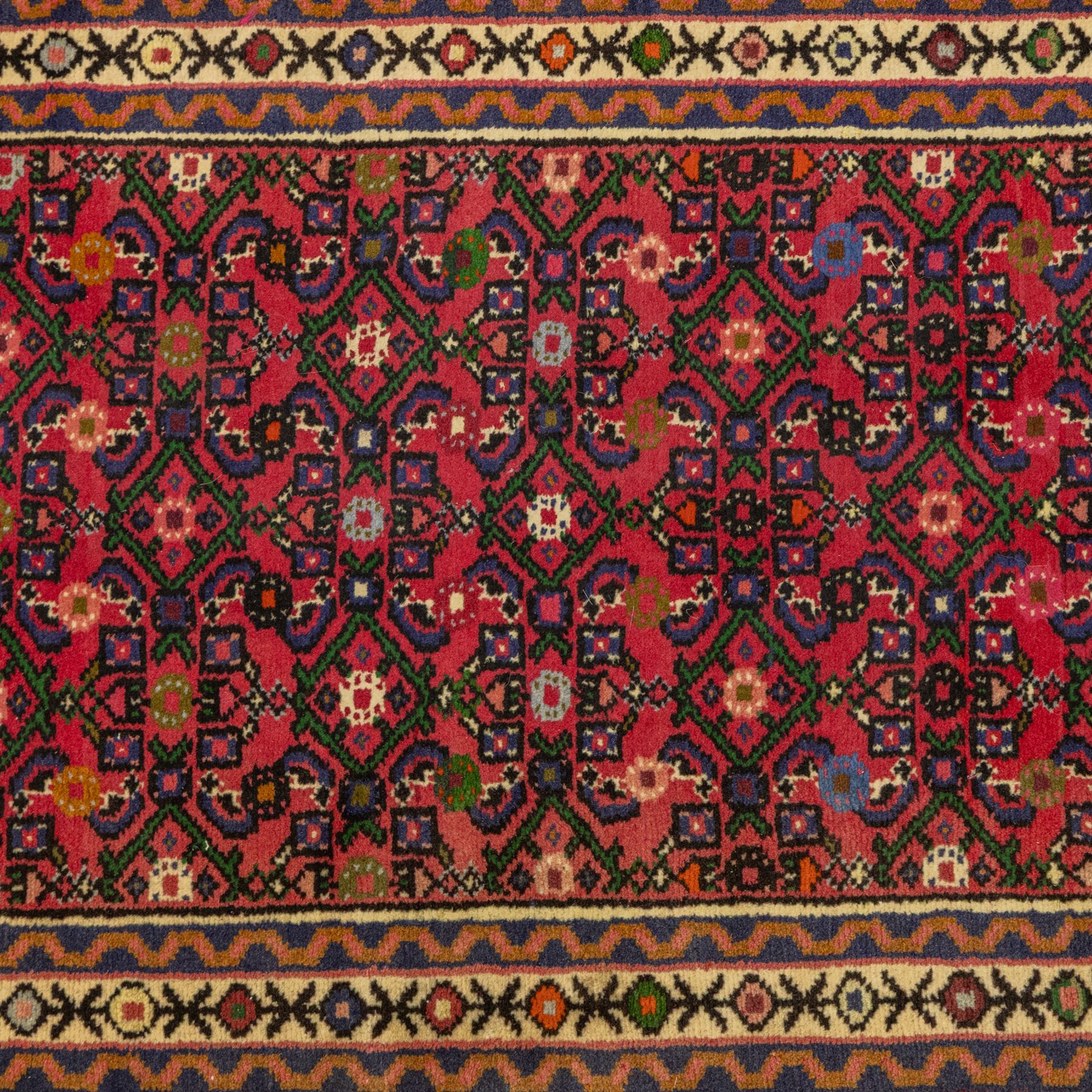North West Persian runner, red field decorated with repeating herati motifs and small flowerheads, enclosed by cream main border with stylised floral motifs and narrow guard borders, fringed ends
