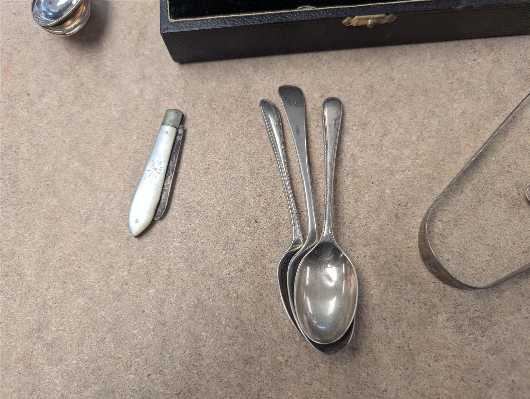Group of silver, comprising mustard pots, open salts, napkin ring, spoons, sugar tongs and fruit knife, all stamped or hallmarked 
