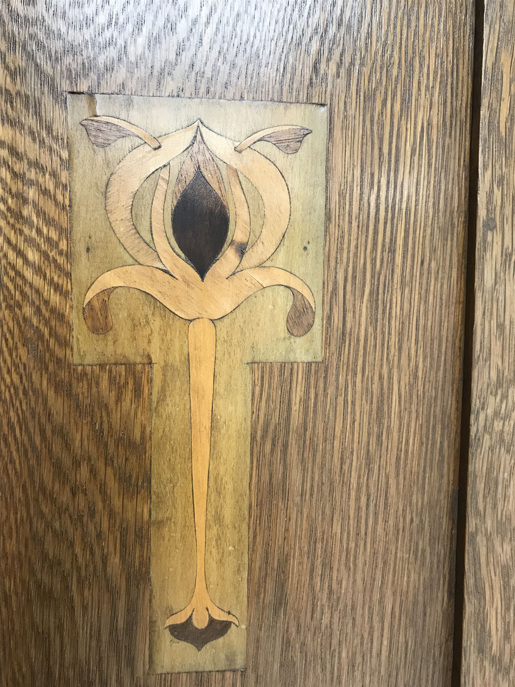 Arts and Crafts period oak wardrobe, projecting shaped cornice, single bevel edged mirrored door above drawer