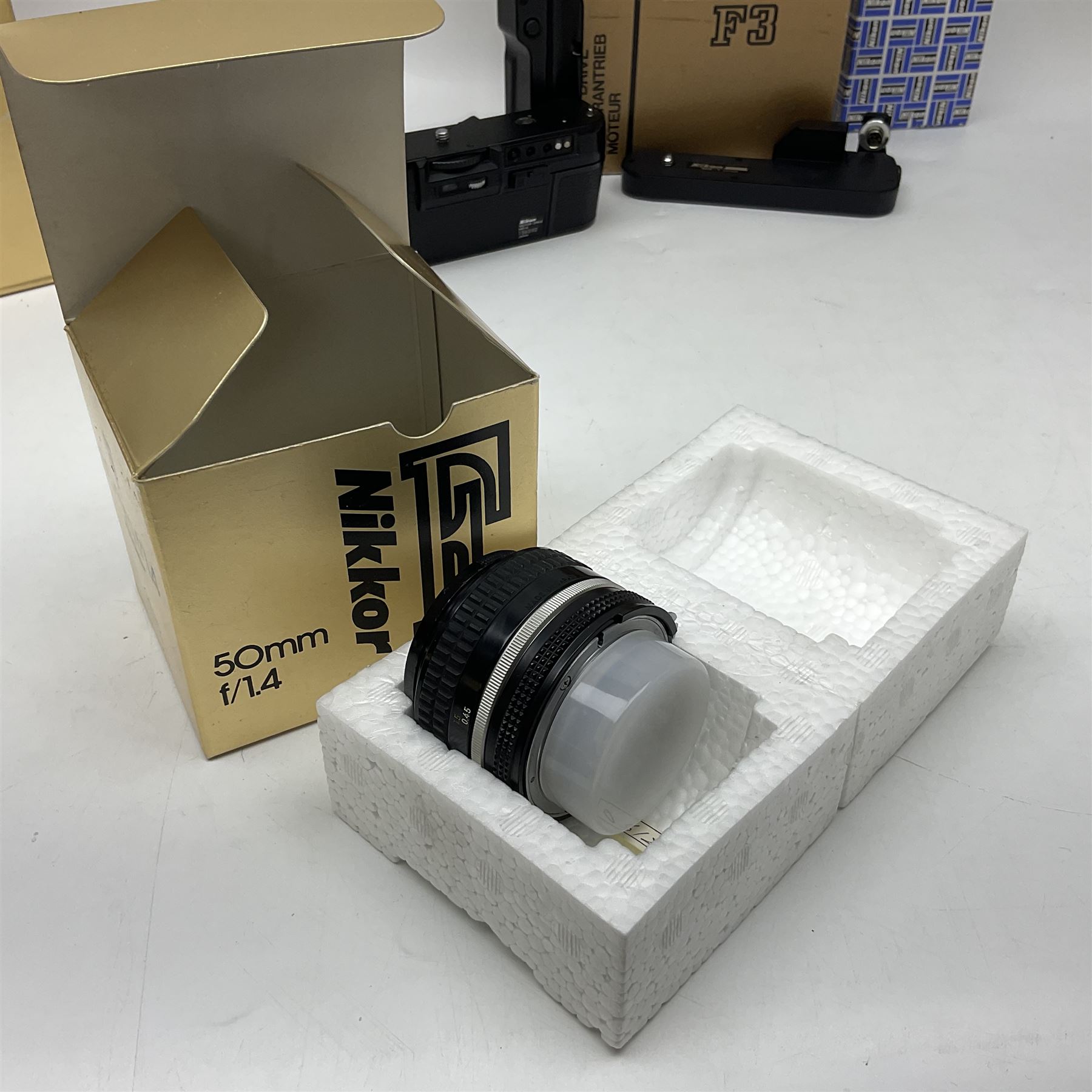 Nikon F3T camera body, in champagne/ titanium colourway, serial no. T8215031, with 'Nikon Nikkor 50mm 1:1.4' lens, Nikon MD4 motor drive, serial no. 156592 and Nikon MK-1 Firing range converter, all with original boxes 